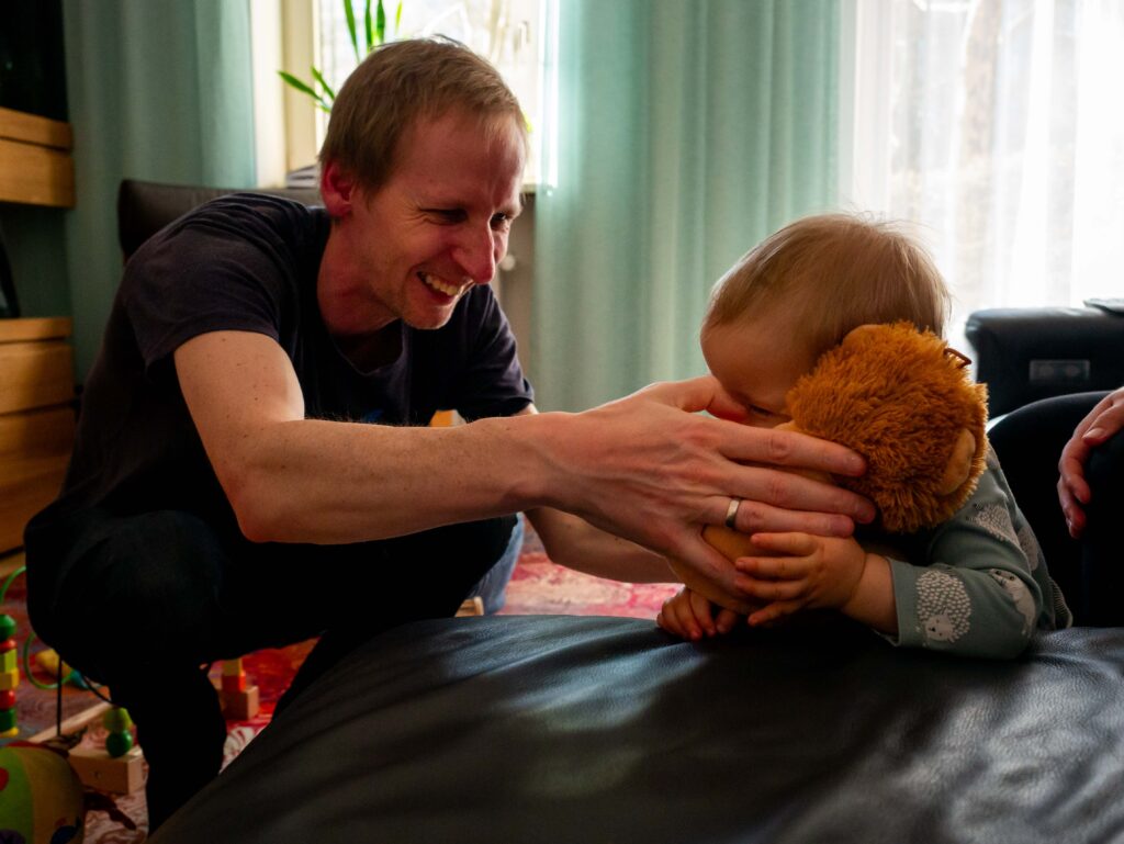 Stoeien met een knuffel tijdens Day-in-the-life familie fotografie aan huis