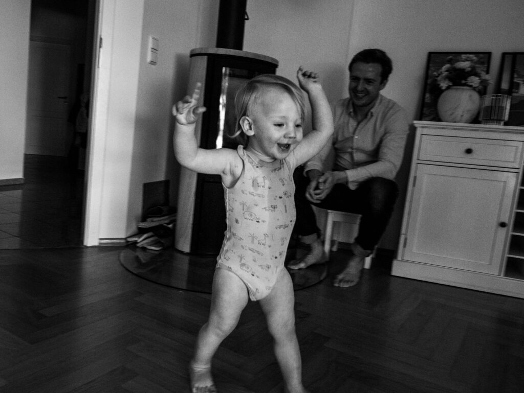 Peuter dansend door de kamer tijdens een familieshoot